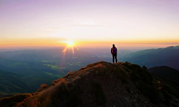 Hiker reaching the summit of a mountain at dawn.  Video