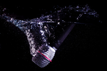 Microphone Splashing into Water on Black Background