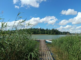 Bubiai lake during sunny day. Sunny day with white and gray clouds in blue sky. Wavy lake. Horizon over water. Bubiu ezeras.	