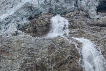 The waterfall flows down from the top of the mountain as a result of melting ice. Environmentally...