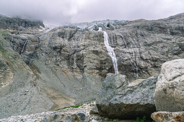 The waterfall flows down from the top of the mountain as a result of melting ice. Environmentally...