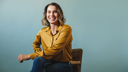 Business executive sitting on a chair, proud of her success in her company