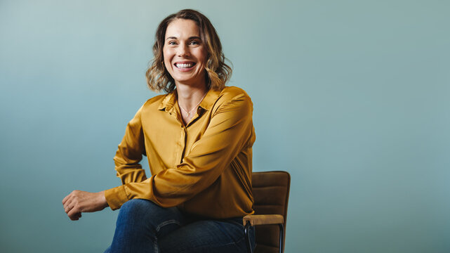 Business executive sitting on a chair, proud of her success in her company