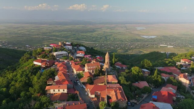 Old Georgian town Signagi in warm sunset lights. Aerial view of Signagi city center and Alazani Valley in the background. Kakheti Region, Georgia