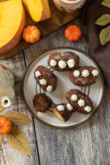 Chocolate rum potato cake with pumpkin on rustic background, homemade vegan dessert. Traditional Eastern European dish with cocoa and butter. Chocolate sweets filled with marzipan. View from above.  