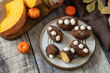 Chocolate rum potato cake with pumpkin on rustic background, homemade vegan dessert. Traditional Eastern European dish with cocoa and butter. Chocolate sweets filled with marzipan.