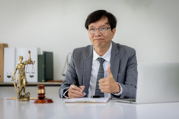 Portrait of mature asian notary public or lawyer working in the office,Male lawyer working at documents laptop in office.