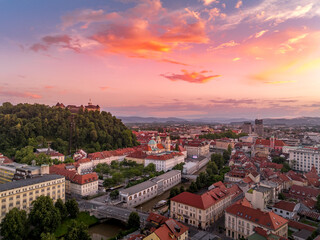 Fototapeta premium Aerial view of central Ljubljana Slovenia with historic buildings, hilltop castle red roof houses, churches in the Slovenian capital sunset colorful sky