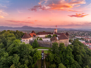 Aerial sunset view of Ljubljana castle in Slovenia , towers, bastions, funicular taking visitors up the hill with colorful sky  © tamas