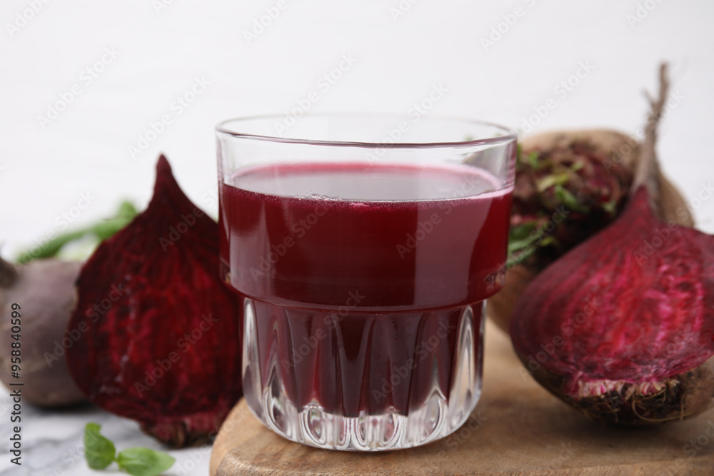 Poster Fresh beet juice in glass and ripe vegetables on table, closeup