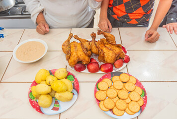 A festive meal setup featuring roasted chicken with apples, boiled potatoes, crackers, and a creamy sauce. The image captures a traditional home-cooked feast ready to be shared with family. 