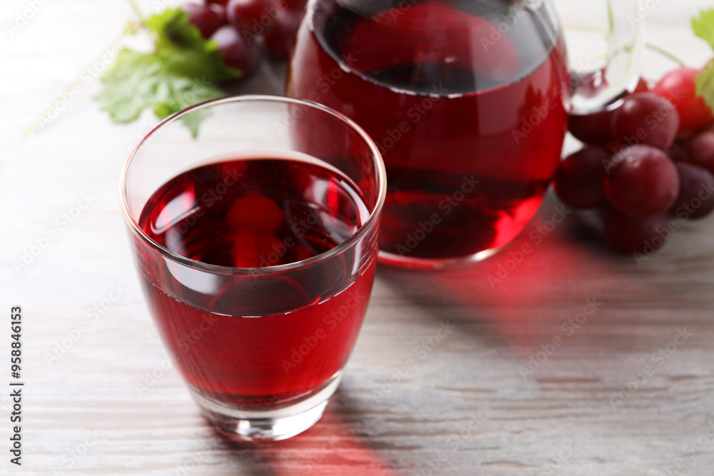 Canvas Prints Tasty grape juice and berries on light wooden table, closeup