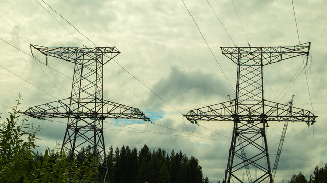 high voltage power lines against a gloomy sky
