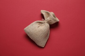 One burlap sack on red background, top view