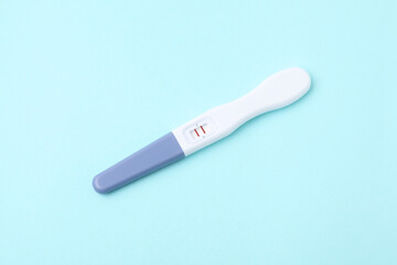 One pregnancy test on light blue background