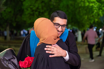 lovely moment between brother and his sister celebrating brother graduation during night
