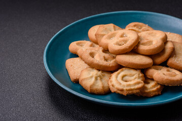 Delicious fresh sweet crispy butter cookies on a dark background