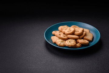 Delicious fresh sweet crispy butter cookies on a dark background