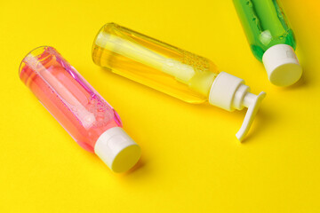 Colorful Bottles of Liquid Soap on Yellow Background