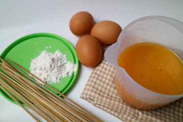 preparation for making egg rolls or telur gulung, using eggs mixed with flour and pepper. And pierced using a skewer.