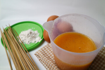 preparation for making egg rolls or telur gulung, using eggs mixed with flour and pepper. And pierced using a skewer.