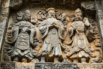 Obraz premium Intricate Stone Carvings Depicting Chinese Deities, a Testament to Ancient Artistic Mastery.