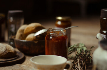 Hora del té: merienda rustica compuesta de té de hierbas, mermelada casera y pan integral en un ambiente calido y hogareño