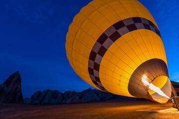 Filling up a yellow hot air balloon in Cappadocia, Turkey.
