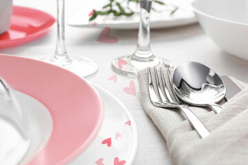 Table setting for romantic Valentine's day celebration. Plates, cutlery and hearts