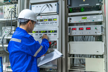Electrical engineer woman checking voltage at the Power Distribution Cabinet in the control...