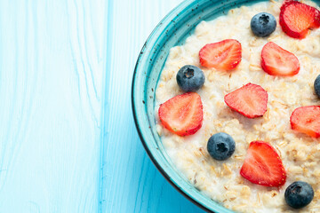 Homemade breakfast . Oatmeal with milk and berries . Top view