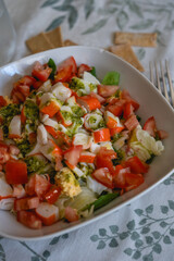 fresh homemade salad with surimi, tomato and lettuce on the table of a house