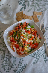 fresh homemade salad with surimi, tomato and lettuce on the table of a house