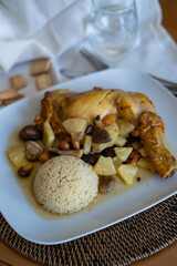 roast chicken with pineapple and mushrooms served with couscous at a home's table