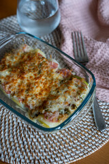 leek au gratin with cheese in the oven at a table at home
