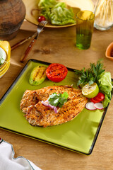 Freshly Grilled Fish on Green Plate with Vegetables in Natural Light