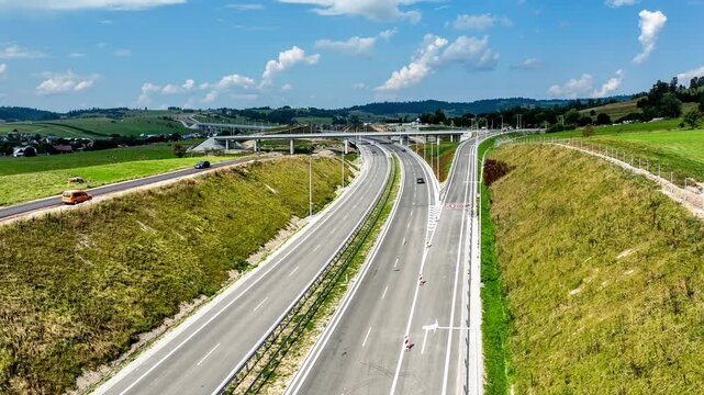 Last fragment of Zakopianka highway, Poland, between Rdzawka nad Nowy Targ with junction with traffic circle, ramps and high viaduct over Klikuszowa village, just opened in September 2024. Aerial view