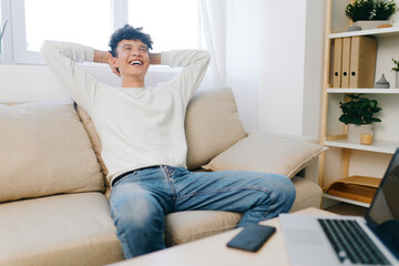 Relaxed man enjoying leisure time at home, smiling on couch in bright room Cozy atmosphere with soft colors creating a sense of comfort and relaxation