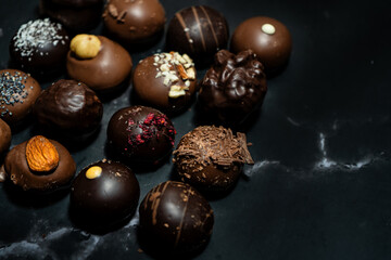 Assorted chocolate bonbons on a black marble
