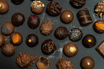 Assorted chocolate bonbons on a black marble
