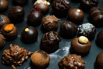 Assorted chocolate bonbons on a black marble