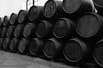 Barrels for whiskey or wine stacked in the cellar.