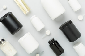 Jars with protein powder on color background, top view. Sports nutrition concept