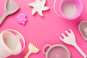 Cute toys for playing with sand on color background, top view