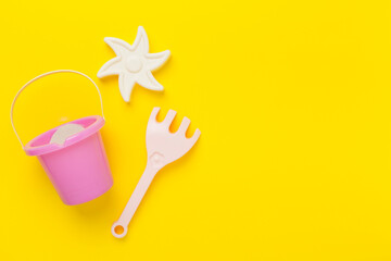 Cute toys for playing with sand on color background, top view