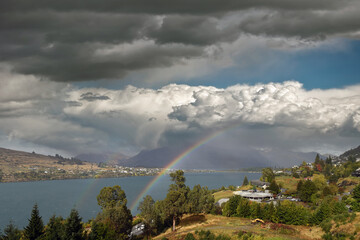 view from Lake Wakatipu to the Walter Peak on a cloudy day with natural rainbow in Queenstown, New Zealand