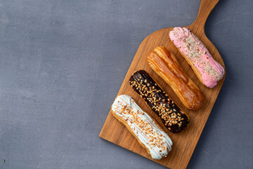 Assorted eclairs on a pastel top view Traditional French dessert