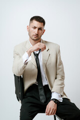 Fashion model, Handsome Man in costume, sits on chair.