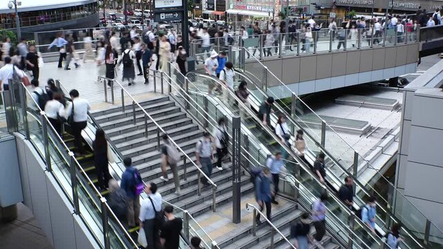 OSAKA, JAPAN - JUNE 2024 : High angle view of crowd of people near the station in busy rush hour. Japanese people, lifestyle, population and diversity concept video. Time lapse shot.