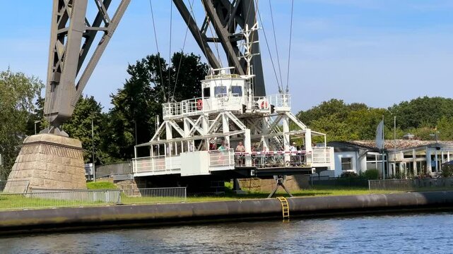 Schwebef&auml;hre Rendsburg suspended ferry crossing from high steel suspension bridge across the kiel canal nord ostsee kanal through germany in summer